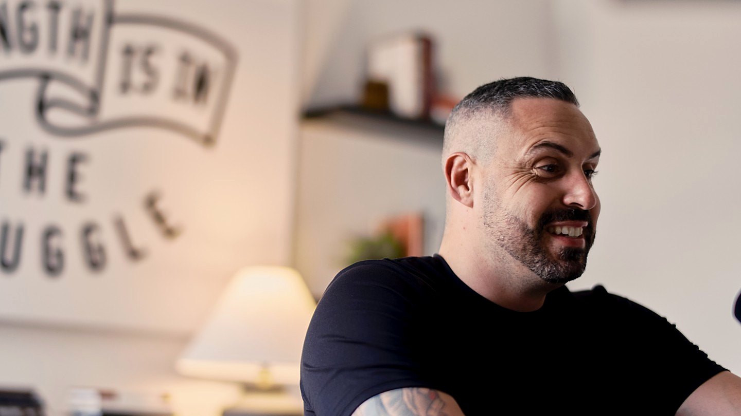 Blake Suddath smiling at his desk. Play the video.