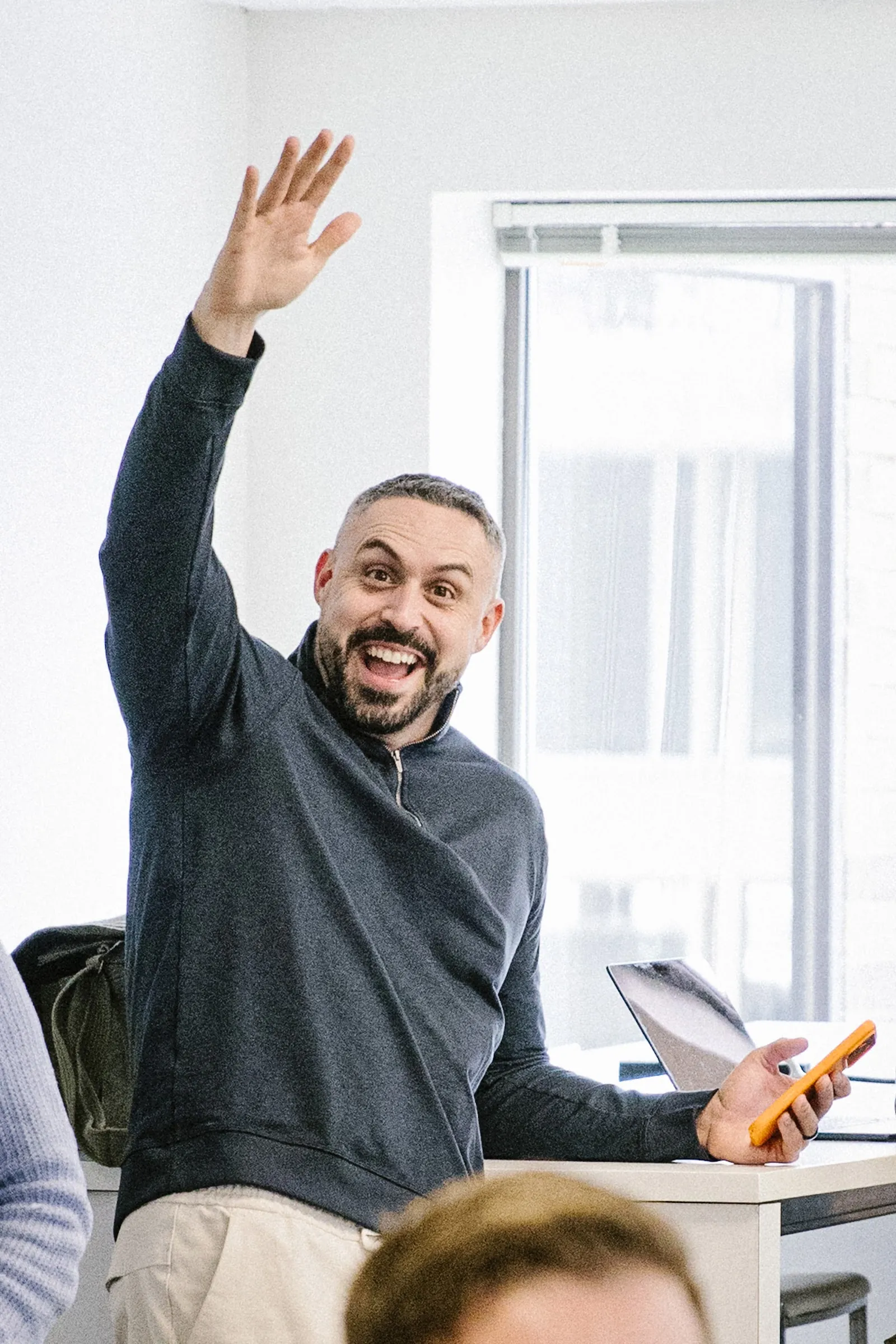 Blake Suddath coaching a room, smiling with his hand up